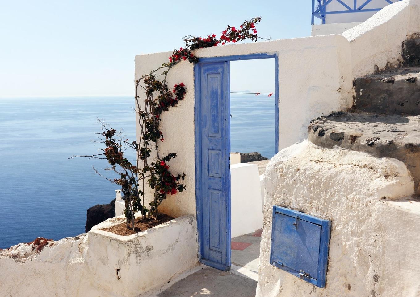 Weiß-blaue Tür auf Santorini mit Blick aufs Mittelmeer