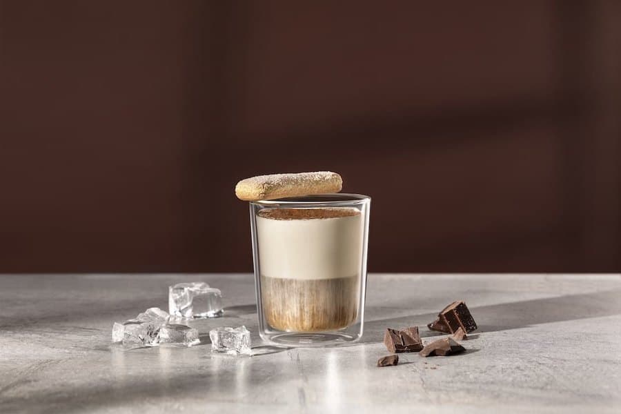 Cremiger Kaffee-Dessert-Drink im Glas mit Löffelbiskuit, Eis und Schokolade