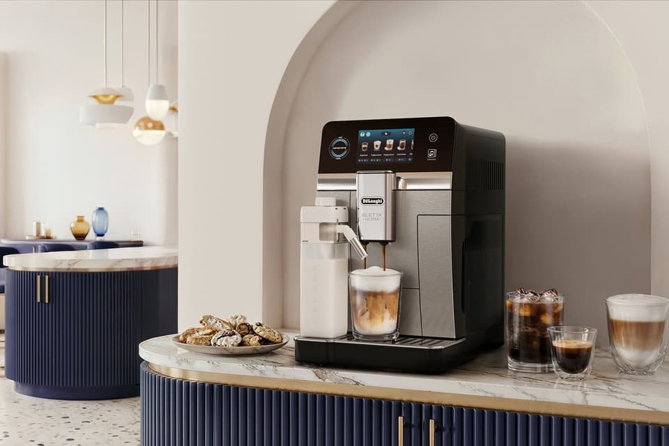 Dekorative Kaffeebar-Ecke mit De'Longhi Eletta Ultra, Cold Brew und Kaffeespezialitäten auf Marmor