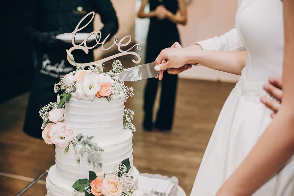 "Love" aus Holz steht auf einer Hochzeitstorte