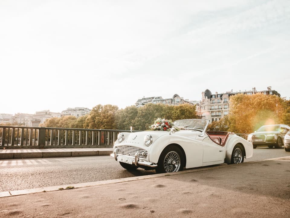 Ein Hochzeitsauto mit Autodeko steht auf einer Brücke