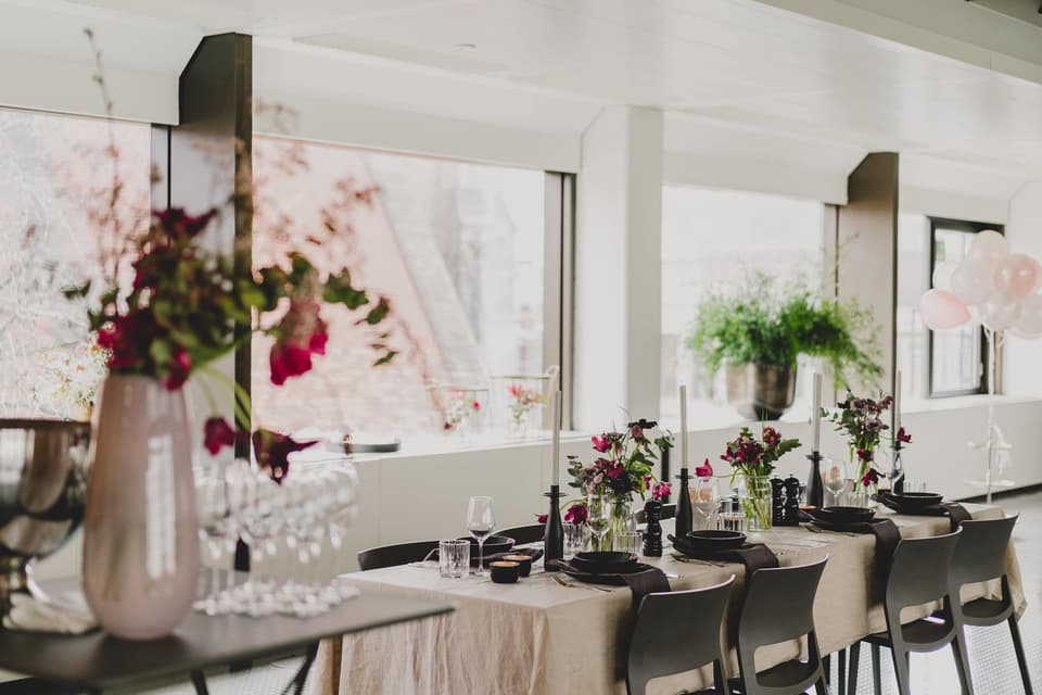Innenbereich einer Hochzeitslocation mit Hochzeitstisch und Dekoration