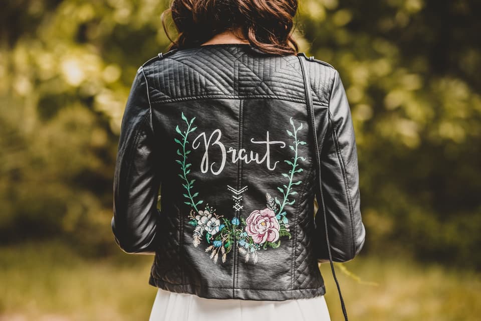 Braut trägt eine beschriftete Lederjacke