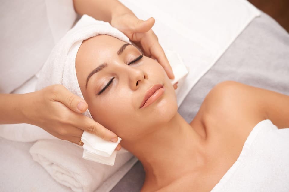 Eine Frau bekommt in einem Spa eine Gesichtsmassage.