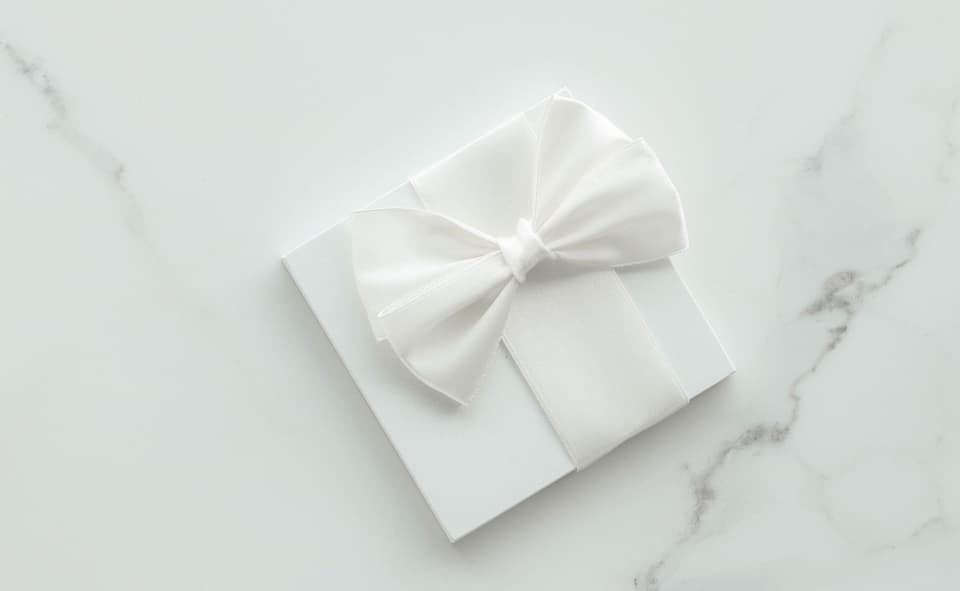 Geschenk mit weißer Schleife