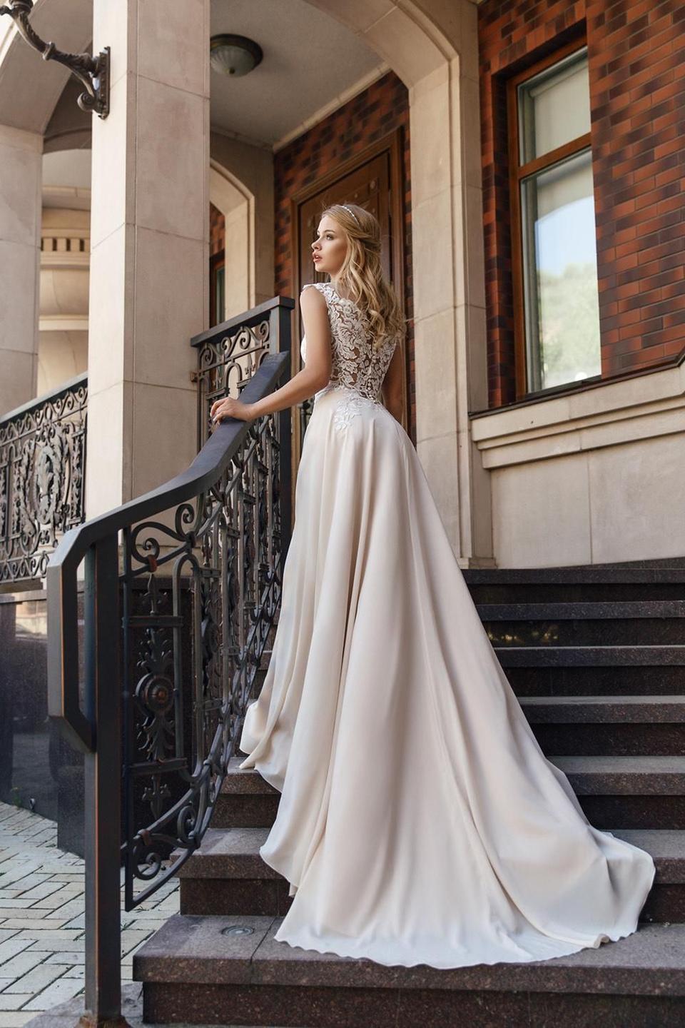 Brautkleid Blush: Braut posiert auf einer Treppe