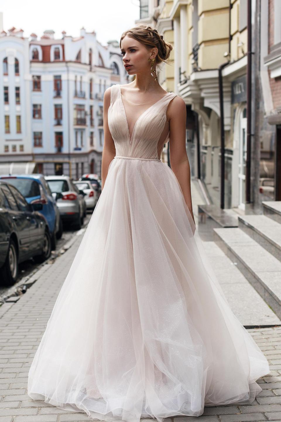 Braut trägt ein Brautkleid in dem Farbton Blush