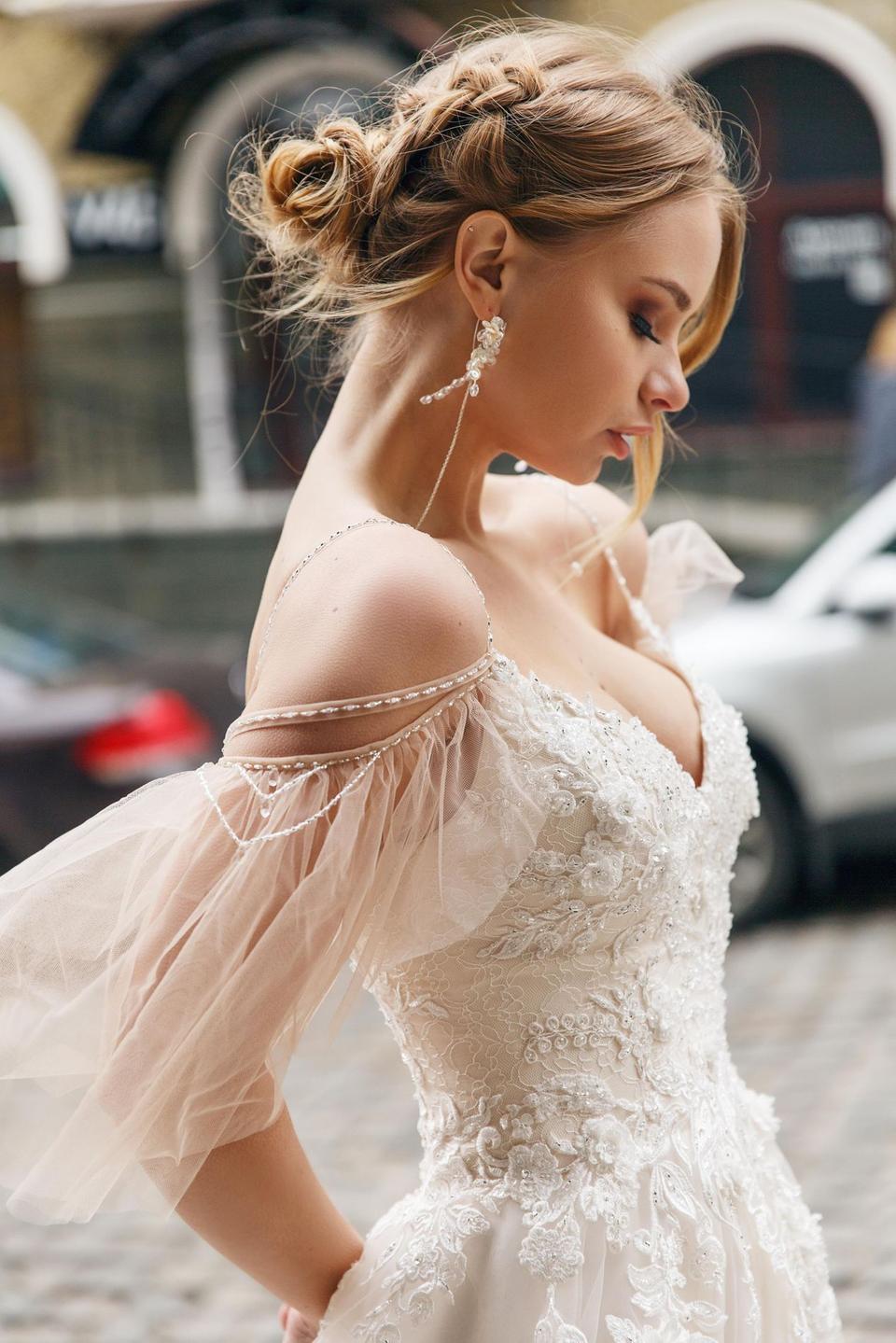 Braut trägt ein Brautkleid in Ivory mit Spitze