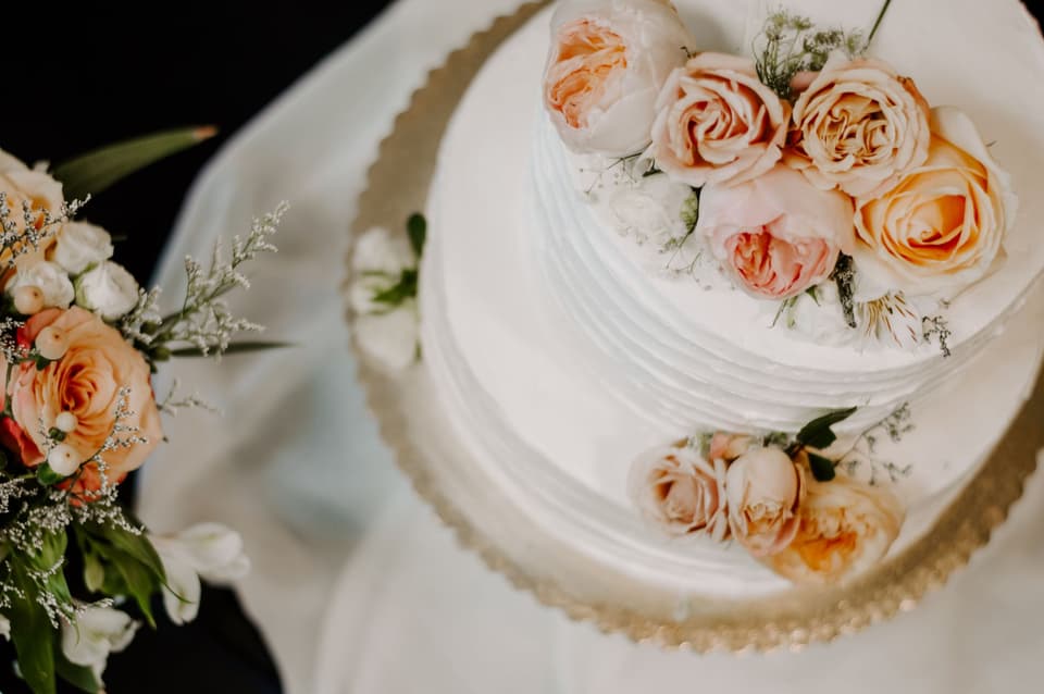 Weiße Hochzeitstorte mit Rosen als Verzierung