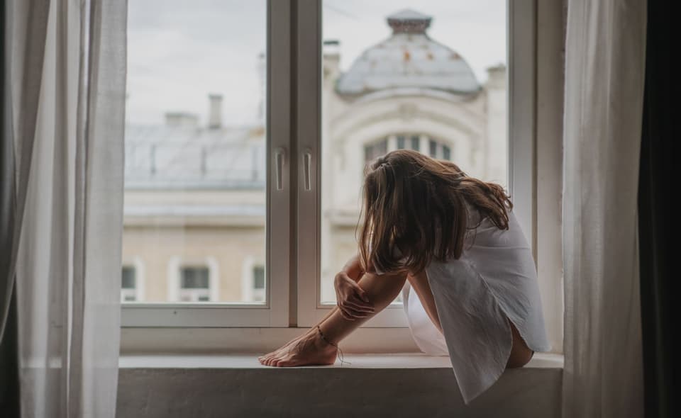 Wahre Liebe verursacht große Emotionen: Trauernde Frau am Fenster