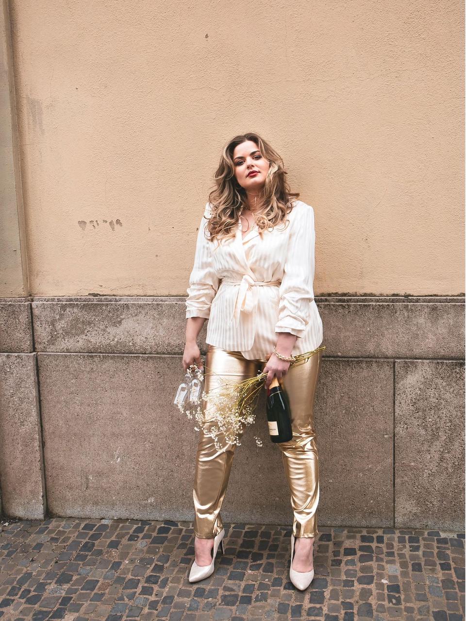 Braut mit Accessoires posiert vor einer Wand