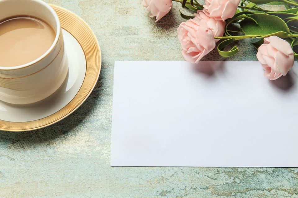 Ein Blatt liegt neben Rosen und einem Café
