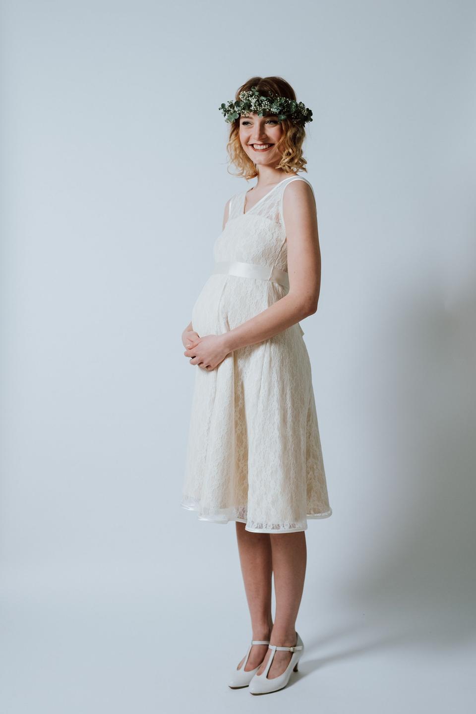 Eine Braut mit kurzem Umstandsbrautkleid