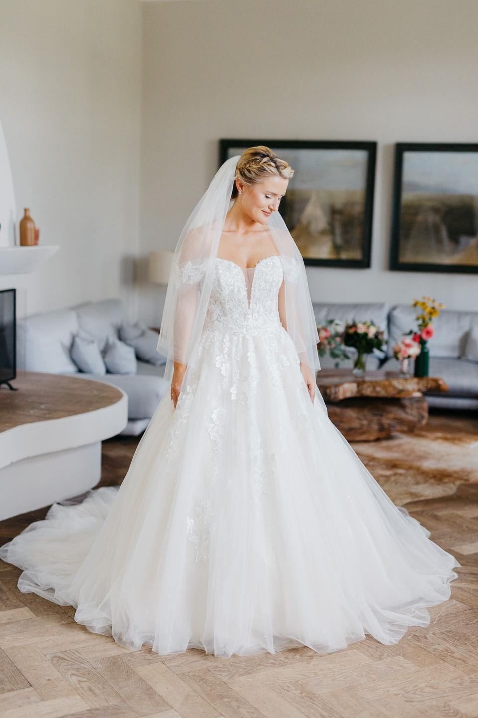 Eine Braut steht mit Prinzessinnen Brautkleid im Raum