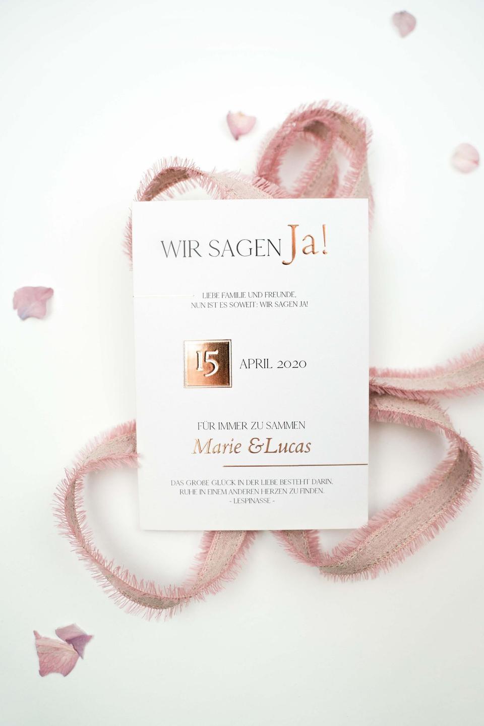 Hochzeitseinladung auf weißem Hintergrund mit rosa Band