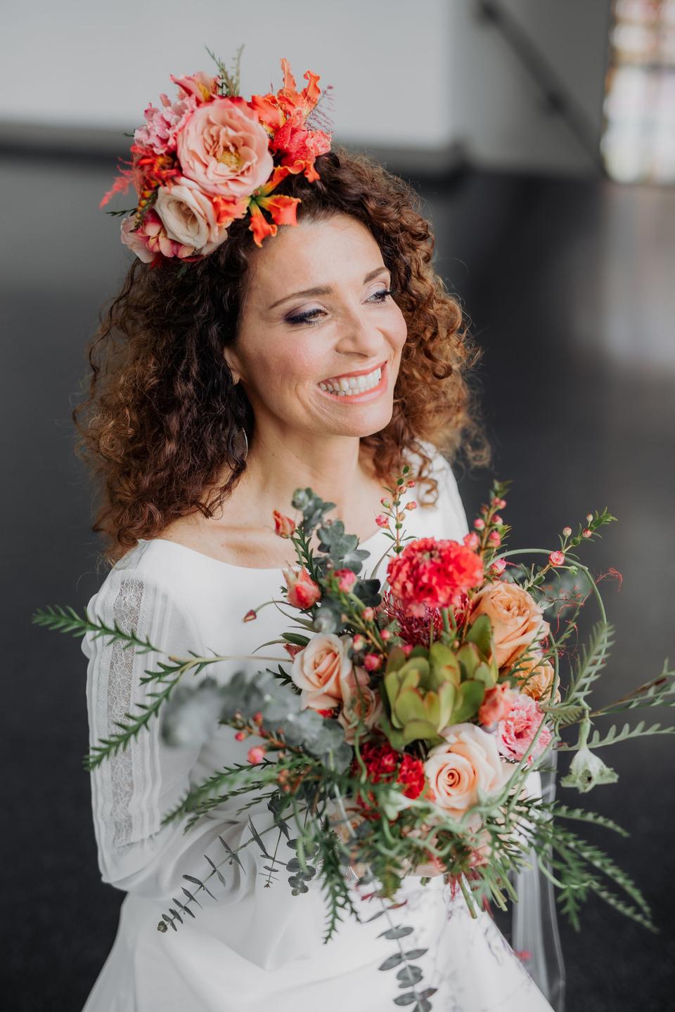 glückliche Braut mit Blumenschmuck im Haar