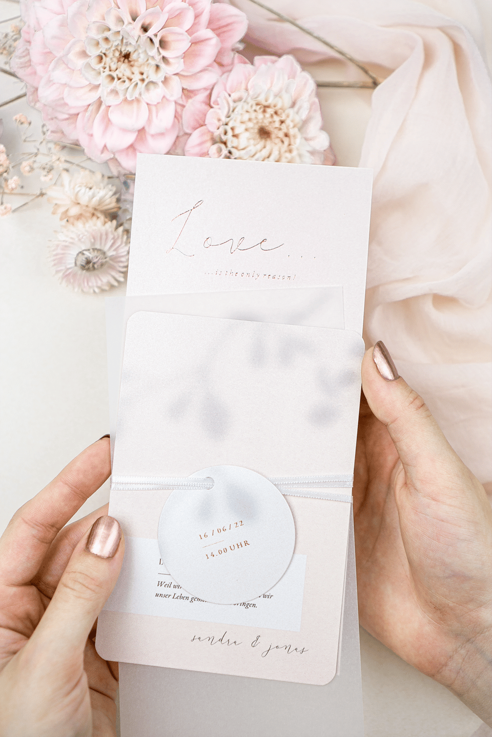 Rosa Hochzeitspapeterie mit Hochzeitstafel im Hintergrund