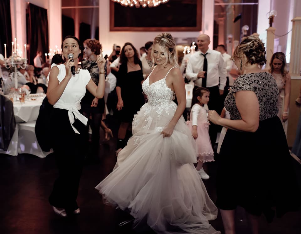 Brautpaar tanzt mit Hochzeitsmoderatorin