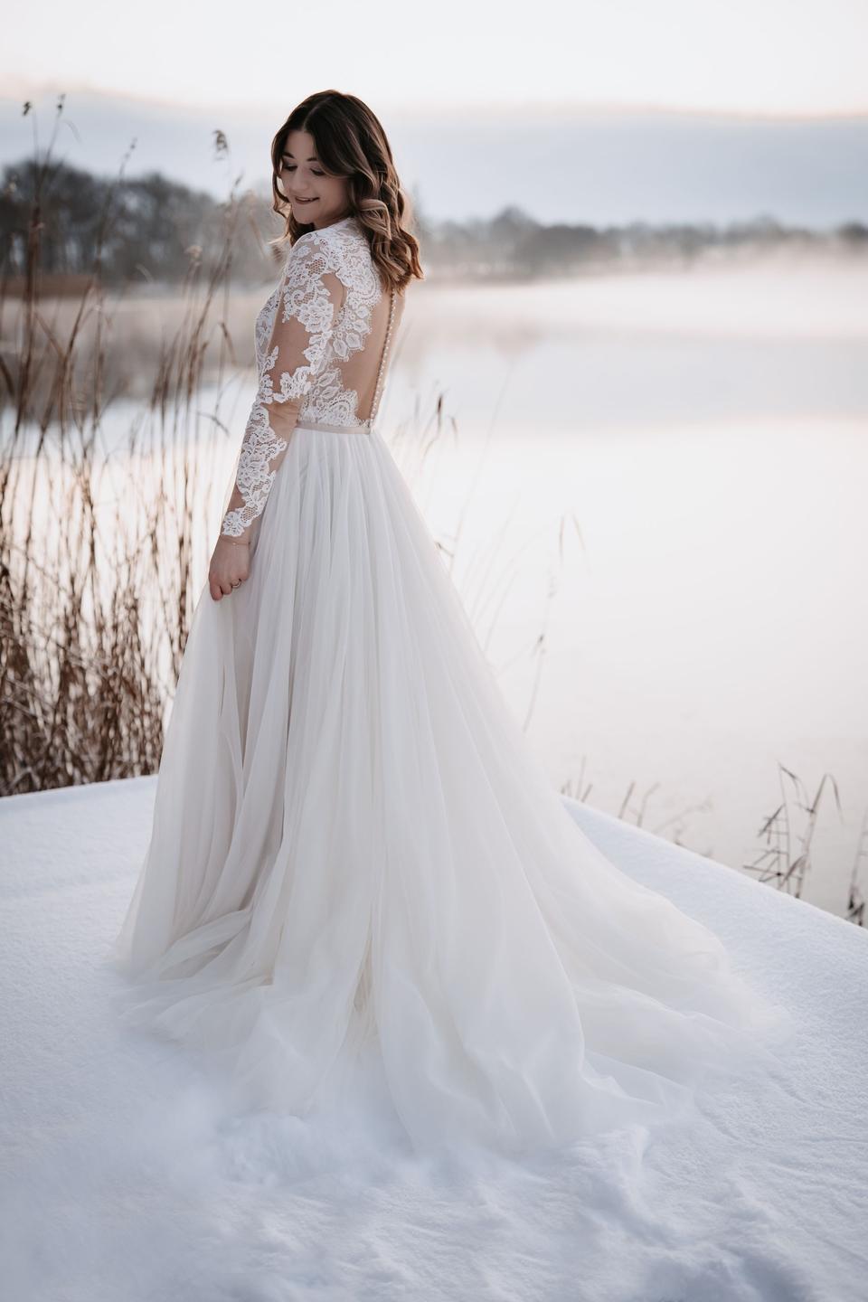 Braut in schickem Brautkleid mit langen SpitzenÀrmeln