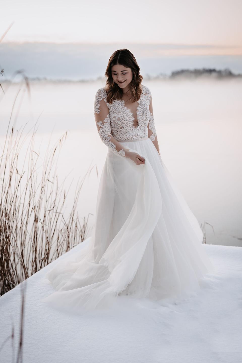 Braut in Hochzeitskleid mit TĂŒllrock und langen Ărmeln
