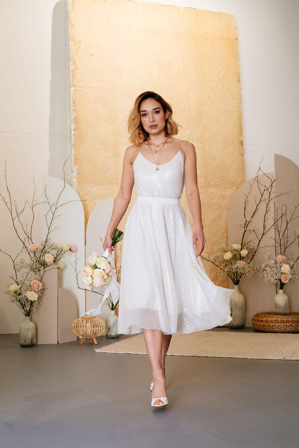 Braut im kurzen Brautkleid läuft auf Kamera zu