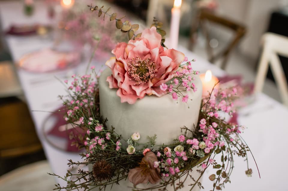 Weiße Hochzeitstorte ist mit Schleierkraut geschmückt