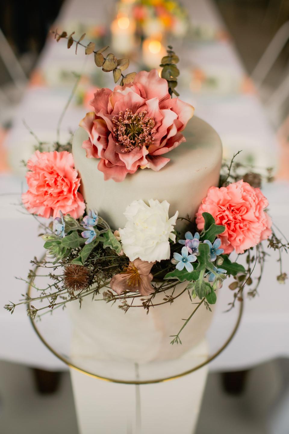 Eine weiße Hochzeitstorte mit vielen Blumen