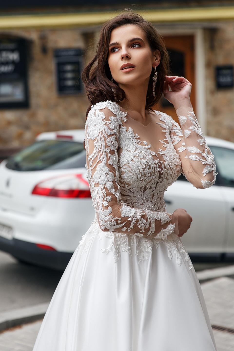 Braut in elegantem Hochzeitskleid mit langen SpitzenÀrmeln