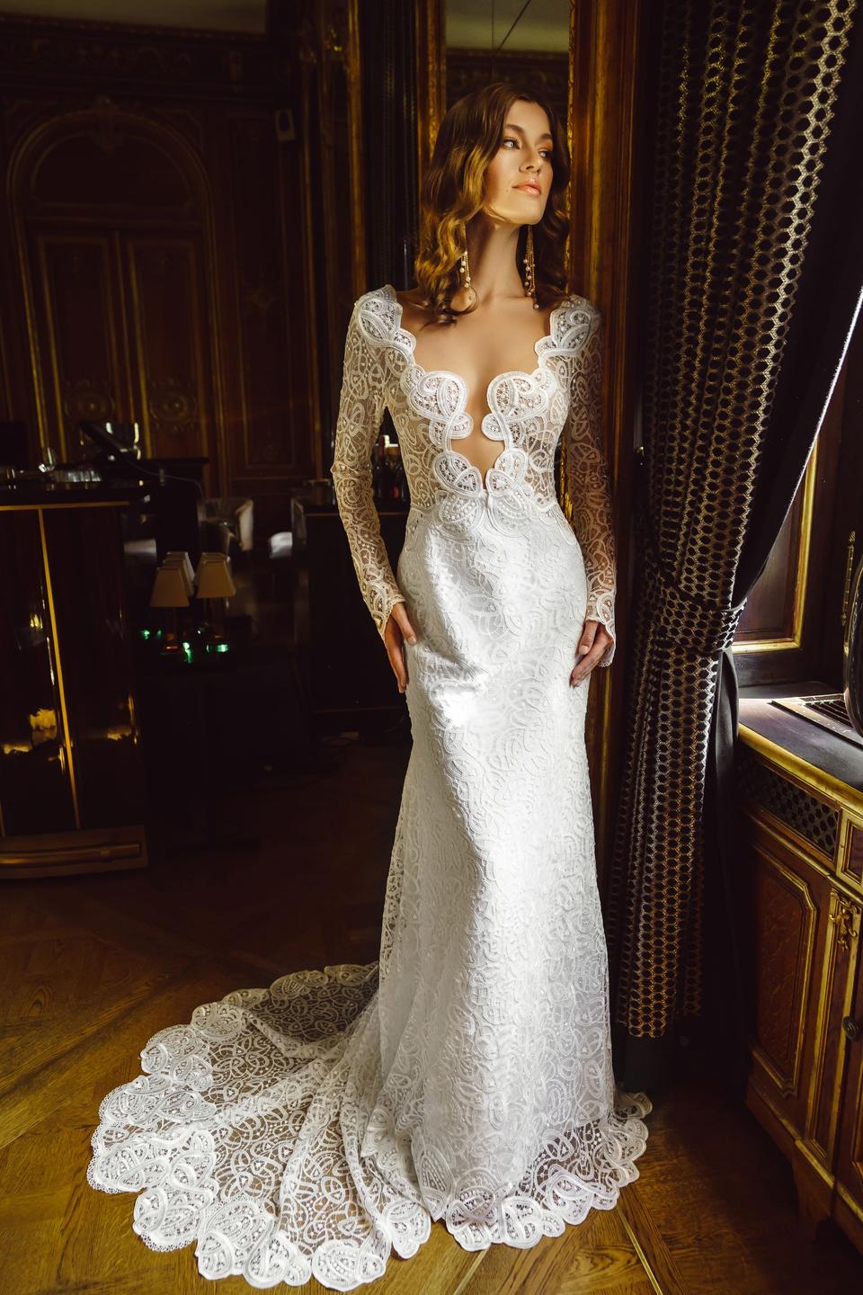 Braut in extravagantem Spitzenkleid mit langen Ărmeln und tiefem Ausschnitt