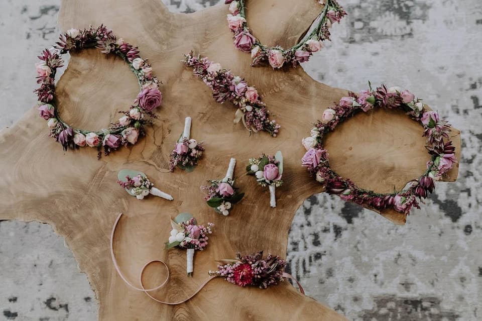 Blumenkränze und Anstecker auf einem Holztisch