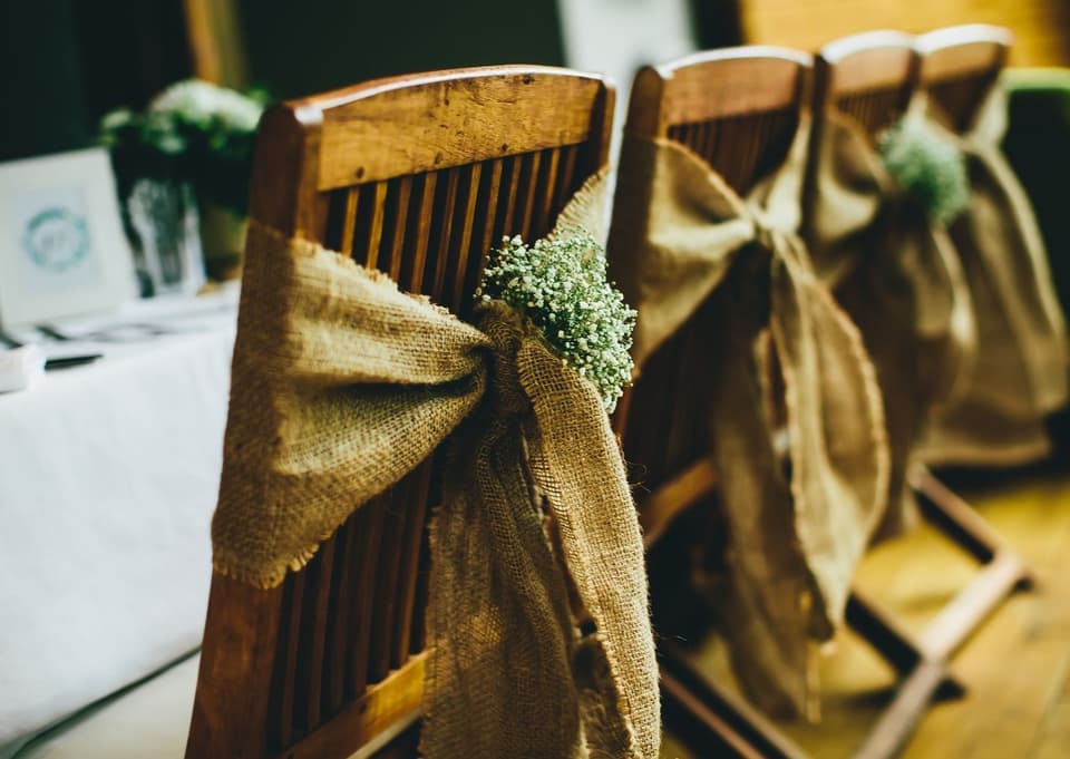 Rustikale Elemente am Tisch und an den Stühlen bei der Hochzeit