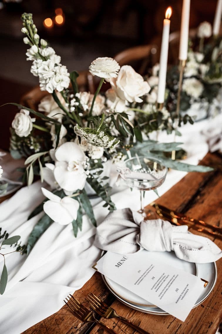 Tischdekoration mit frischen Blumen und Menükarte
