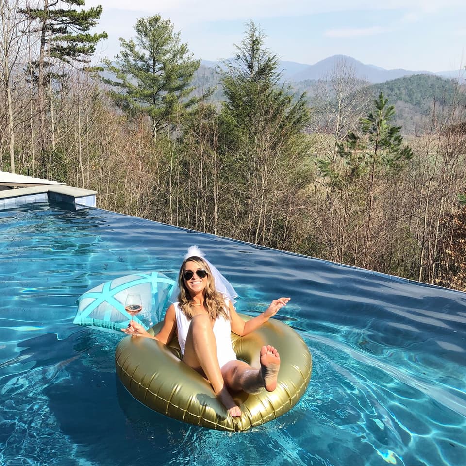 Braut mit Schwimmring im Pool bei ihrer Bachelorette Party