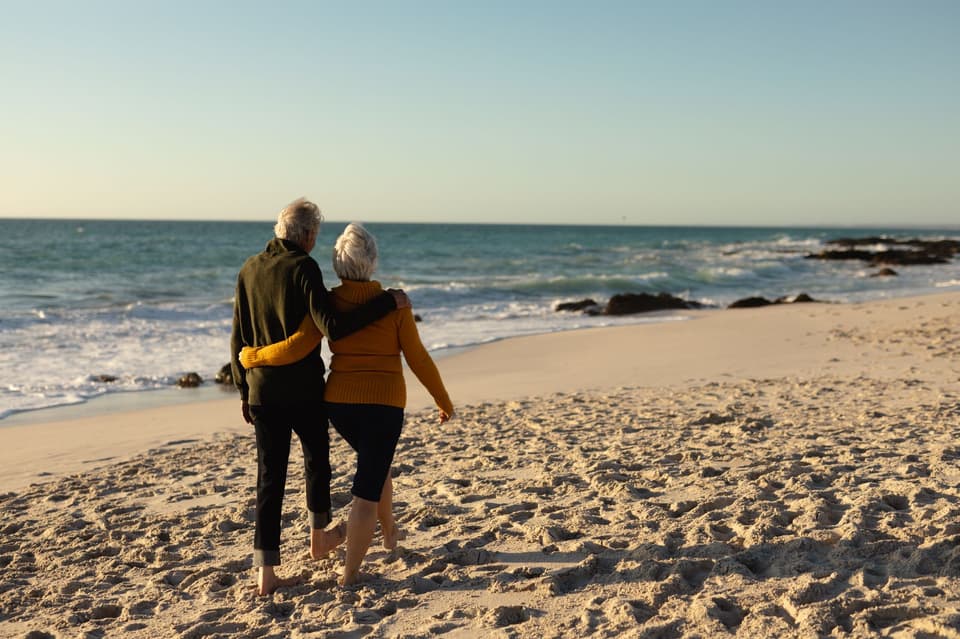 Ein Brautpaar geht am Strand spazieren