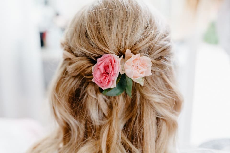 Die Braut trägt eine offene Brautfrisur mit Blumen.