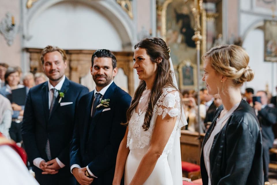 Eine Braut und ein Bräutigam schauen sich in einer Kirche an.