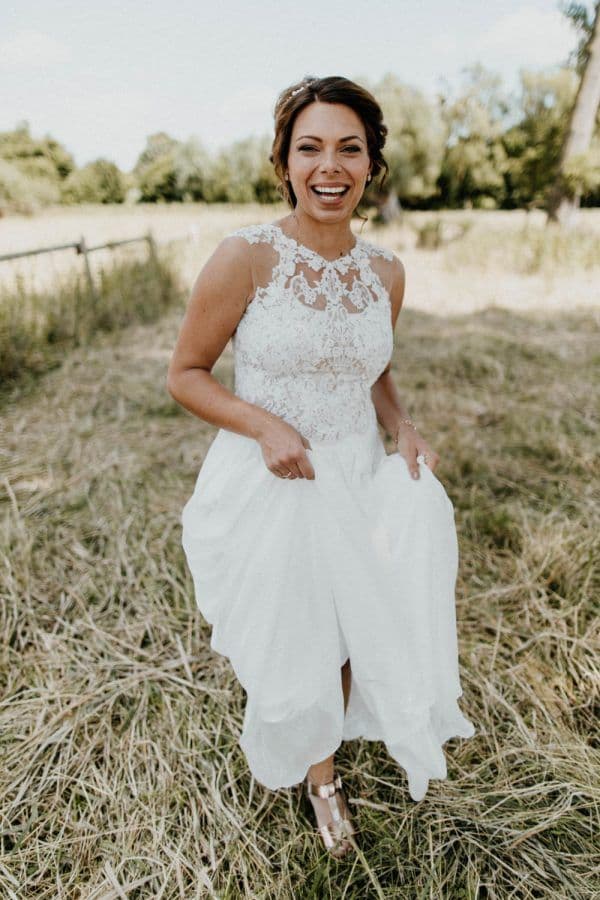 Die Braut trägt ein Neckholder Brautkleid und dazu eine Hochsteckfrisur.