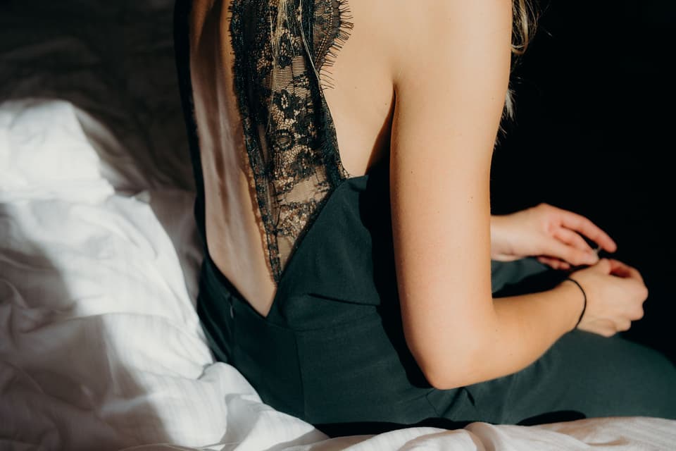 Eine Braut trägt ein schwarzes Hochzeitskleid mit einem tiefen Rückenausschnitt.