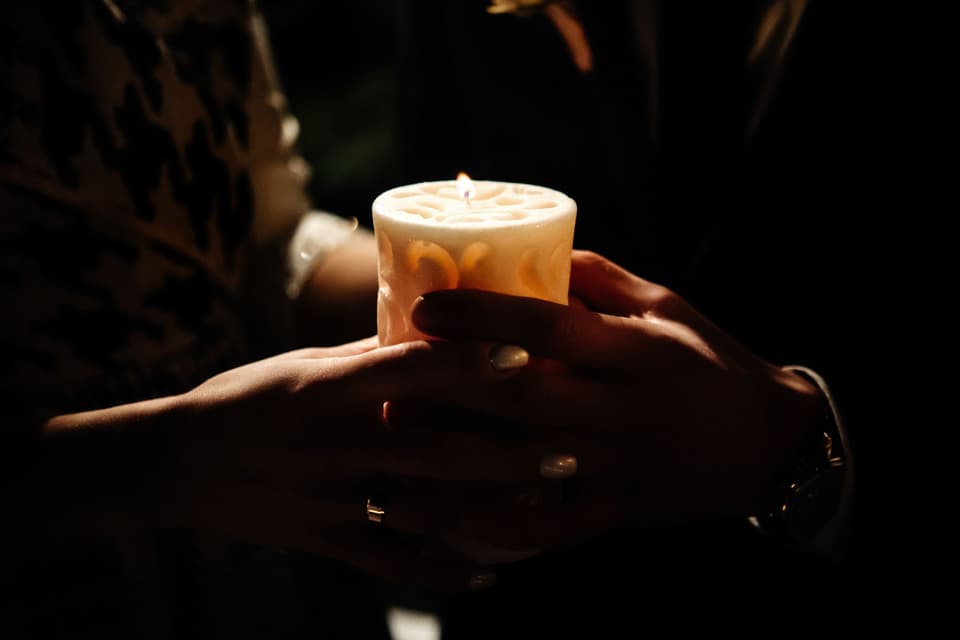Brautpaar hält Hochzeitskerze im dunkeln