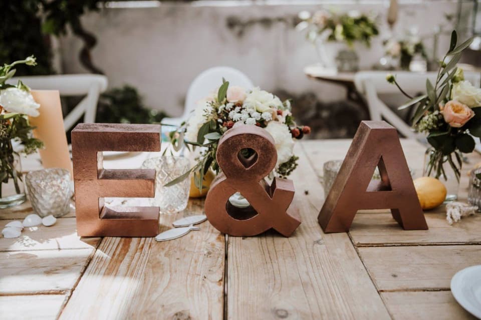 Hochzeitstafel dekoriert mit den Anfangsbuchstaben des Brautpaares