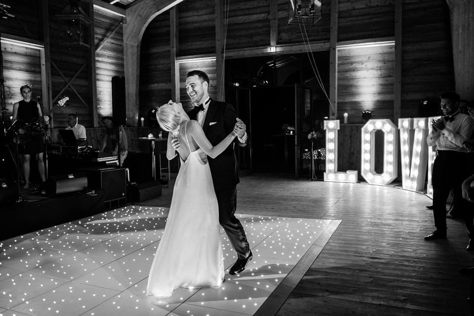 Tanzendes Brautpaar mit Love Schild