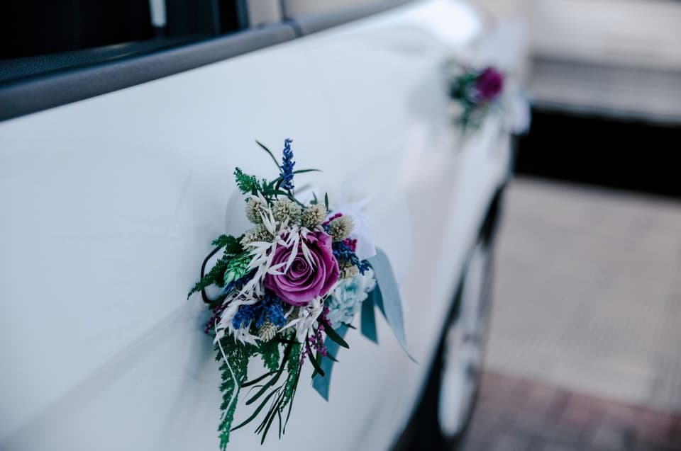 Zarter Blumenschmuck am Brautauto