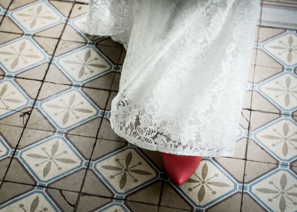 Ein Spitzenkleid mit roten Schuhen