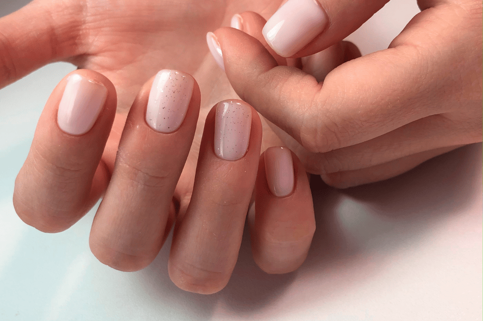 Die Braut trägt Nagellack im Nude-Look mit Glitzer.