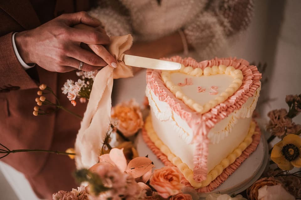 Das Brautpaar schneidet die Hochzeitstorte an.