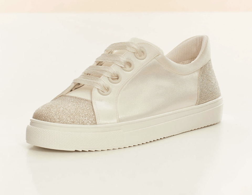 Ein Paar weiße Turnschuhe mit Glitzerdetails.