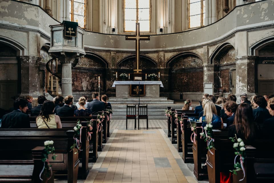 In der Kirche warten Gäste aufs Brautpaar