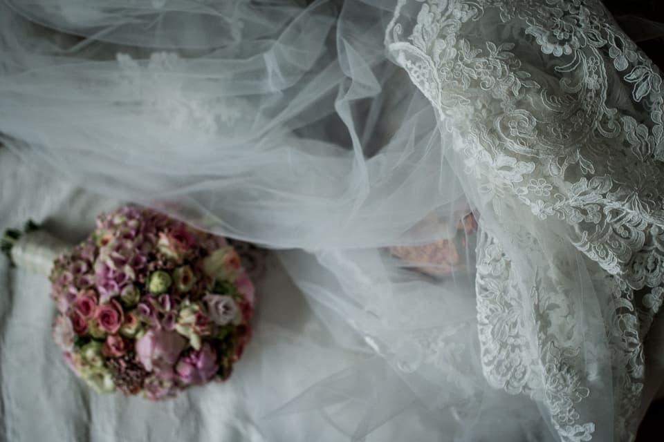 Stilleben von Brautkleid, Schleier und Blumenstrauß