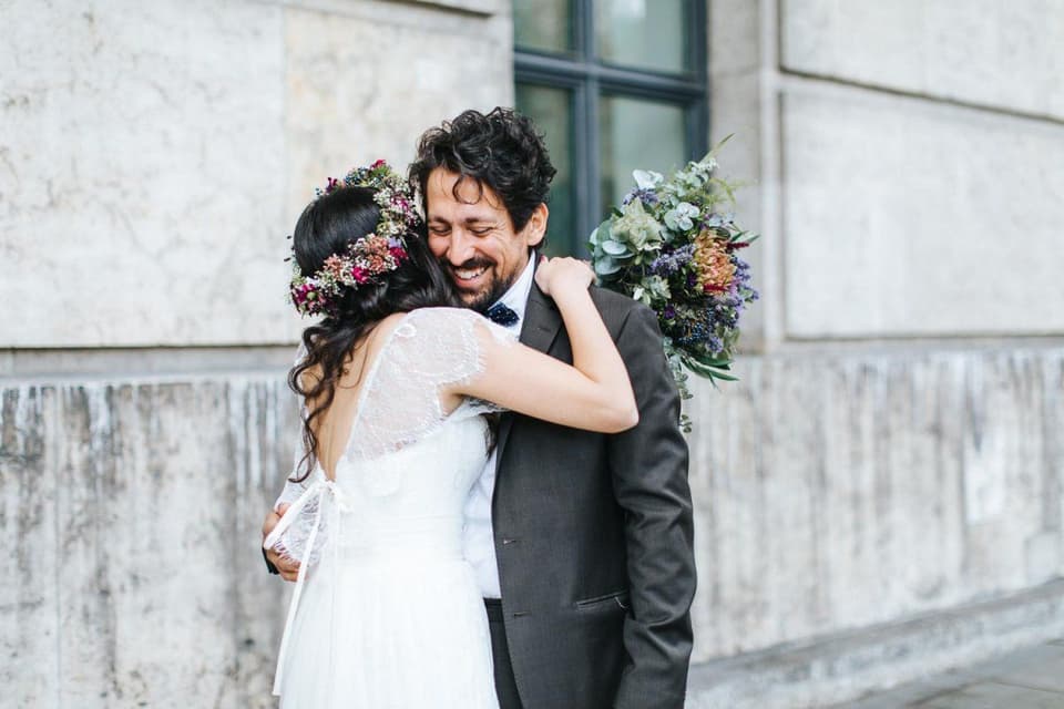 Hochzeitscountdown: Braut mit Brautstrauß umarmt Bräutigam