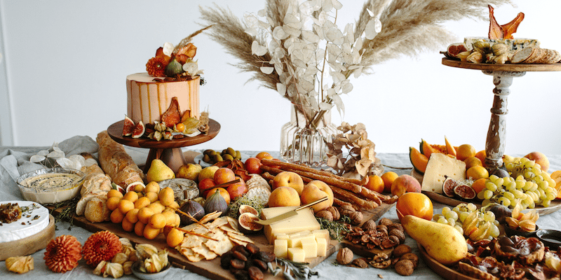 Leckerer Grazing Table mit Früchten, Käse & Torte